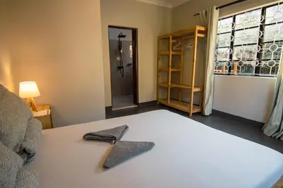 a room with a bed with a bow tie on it at Open Gate House in Arusha