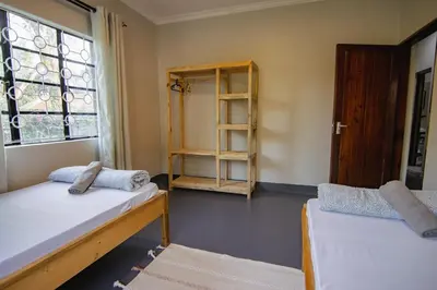 a room with two beds and a window at Open Gate House in Arusha
