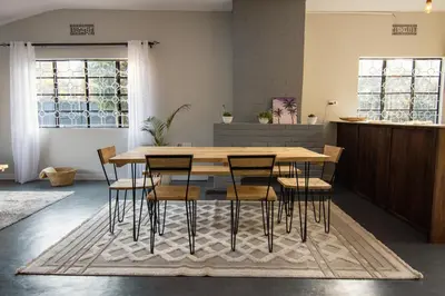 a dining room with a wooden table and chairs at Open Gate House in Arusha