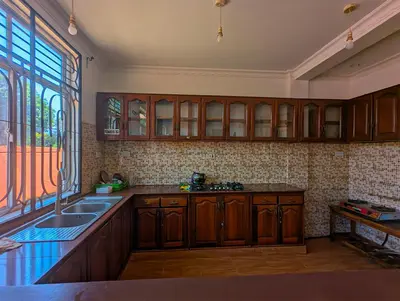 a kitchen with wooden cabinets and a sink and a window at Horizon Kili Retreat in Moshi