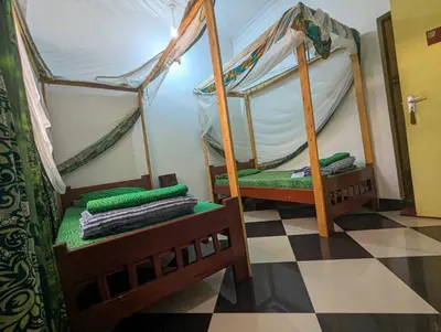 a room with two bunk beds on a checkered floor at Horizon Kili Retreat in Moshi
