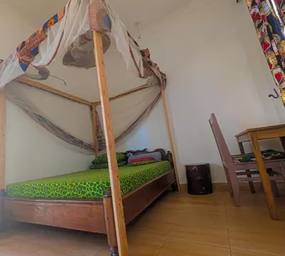 a bedroom with a bunk bed with green sheets at Horizon Kili Retreat in Moshi