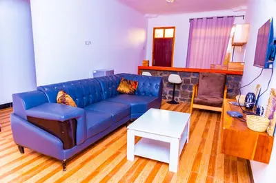 a living room with a blue couch and a table at Kaya homestay in Zame