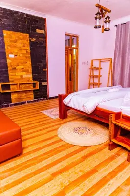 a bedroom with a bed and a wooden floor at Kaya homestay in Zame