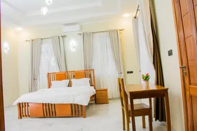 a bedroom with a bed and a table and a desk at KiliView Homestay in Moshi