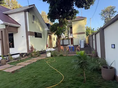 a yard with a hose in front of a house at KiliView Homestay in Moshi