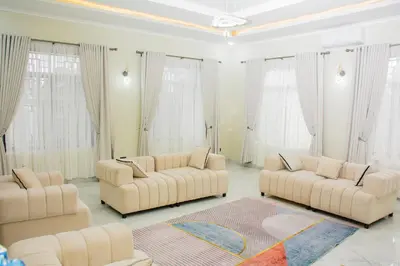 a living room with two couches and a rug at KiliView Homestay in Moshi