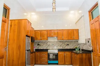 a kitchen with wooden cabinets and a stove at KiliView Homestay in Moshi