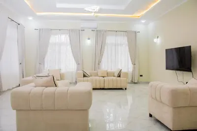 a living room with two couches and a flat screen tv at KiliView Homestay in Moshi