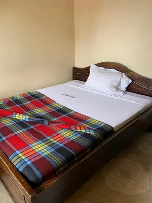 a bed with a colorful plaid blanket on it at Golden View Hotel in Moshi