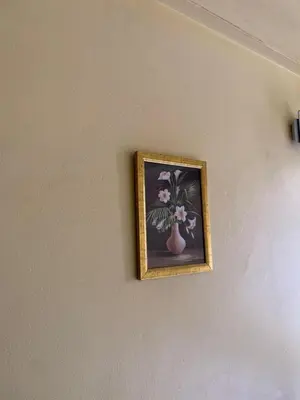 a picture of flowers in a vase on a wall at Golden View Hotel in Moshi