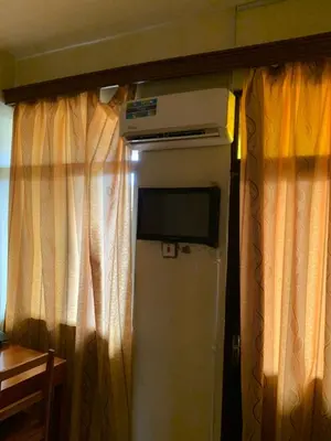 a room with a television and a room with curtains at Golden View Hotel in Moshi