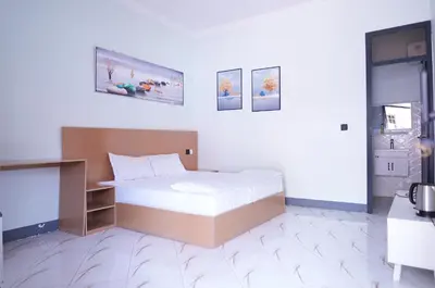 a bedroom with a bed in a white room at Hotel near the clock tower in Arusha