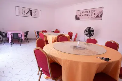 a meeting room with tables and chairs and signs on the wall at Hotel near the clock tower in Arusha