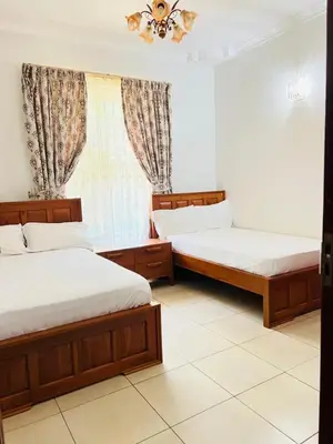 a bedroom with two beds and a window at Aviator Safari bnb in Arusha