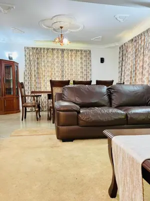 a living room with a leather couch and a table at Aviator Safari bnb in Arusha