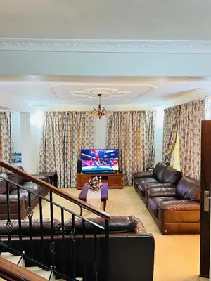 a living room with a couch and a flat screen tv at Aviator Safari bnb in Arusha