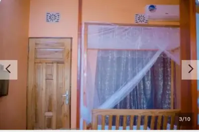 a bedroom with a crib and a window with a curtain at Antelope homestay in Sanya Chini Station