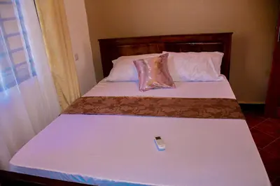 a bed with a remote control sitting on top of it at Antelope homestay in Sanya Chini Station