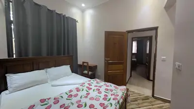 a bedroom with a bed with a floral bedspread at Dawson's Homestay in Msaranga