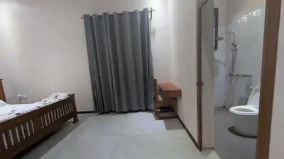 a bathroom with a bed and a shower and a toilet at Dawson's Homestay in Msaranga