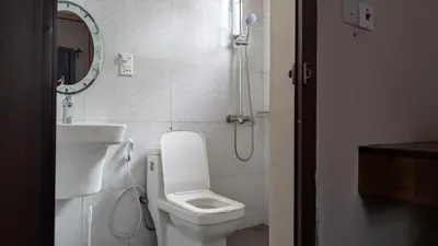 a bathroom with a toilet and a sink and a shower at Dawson's Homestay in Msaranga