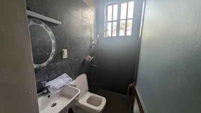 a bathroom with a sink and a toilet and a window at Dawson's Homestay in Msaranga