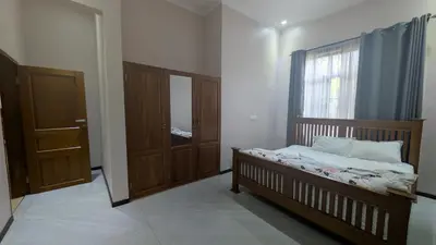 a small bedroom with a bed and a window at Dawson's Homestay in Msaranga