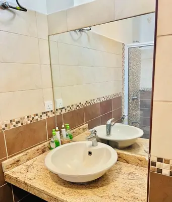 a bathroom with a sink and a mirror at JJ Comfort Homes in Arusha