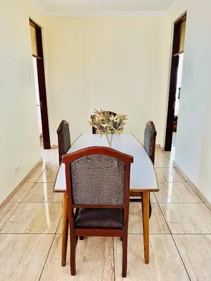 a dining room table and chair with a vase on it at JJ Comfort Homes in Arusha