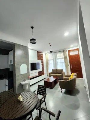 a living room with a table and a couch at Karibu Haven Apartments in Arusha