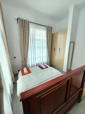 a bed in a room with a large mirror at Karibu Haven Apartments in Arusha