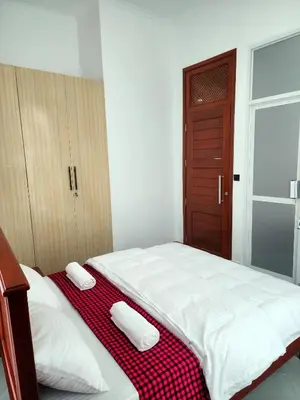 a bedroom with a bed with a red and white blanket at Karibu Haven Apartments in Arusha