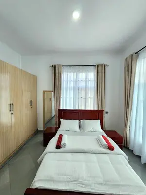 a bedroom with a large bed with red pillows on it at Karibu Haven Apartments in Arusha