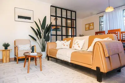 a living room with a couch and a chair at LEGIT HOUSE Arusha in Arusha