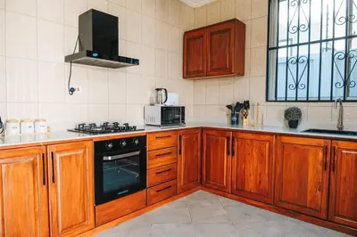 a kitchen with wooden cabinets and a stove top oven at LEGIT HOUSE Arusha in Arusha