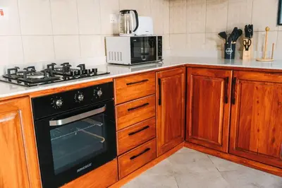 a kitchen with a black stove and a microwave at LEGIT HOUSE Arusha in Arusha