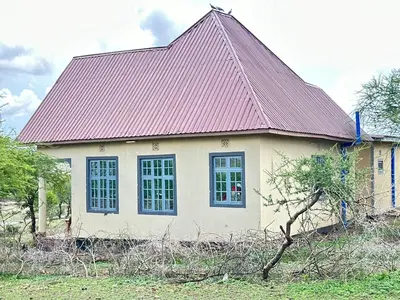 a small white house with a red roof at Oltare House in Makuyuni
