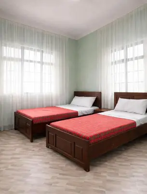 two beds sitting in a room with windows at Oltare House in Makuyuni