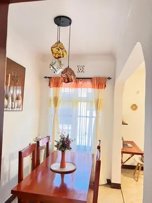 a dining room with a table and a window at Lululiving Homes in Arusha