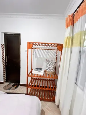 a room with a bed and a curtain at Lululiving Homes in Arusha