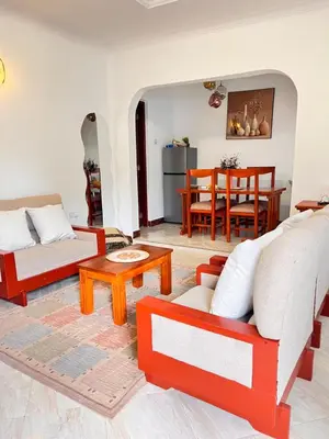 a living room with red and white furniture and a table at Lululiving Homes in Arusha