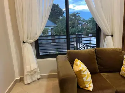 a living room with a couch and a large window at Vista Montage Homestay in Uru