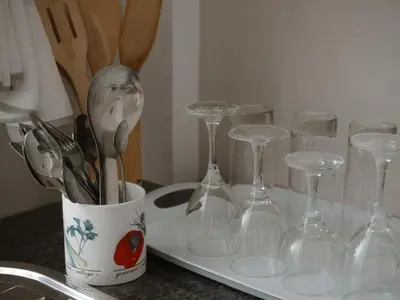 a kitchen counter with wine glasses and a container of utensils at Vista Montage Homestay in Uru
