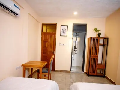 a room with a bed and a table and a shower at Kiliscape Abode in Uru