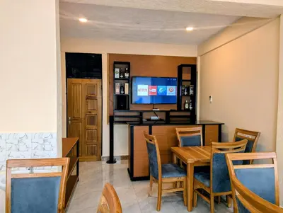 a dining room with a table and a television at Kiliscape Abode in Uru