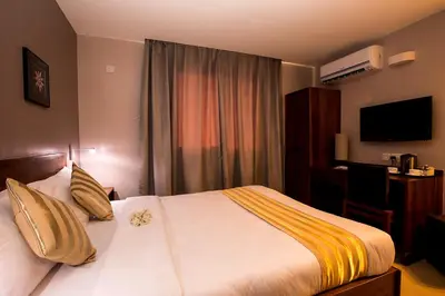 a hotel room with a bed and a desk at Venus Premier Hotel in Arusha