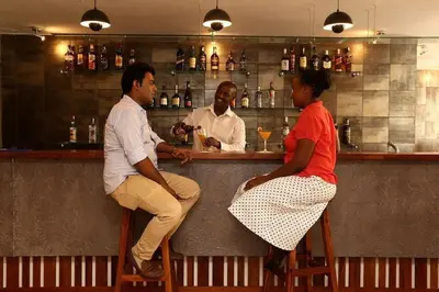 a group of people sitting at a bar at Venus Premier Hotel in Arusha
