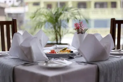 a table with a plate of food on top at Venus Premier Hotel in Arusha