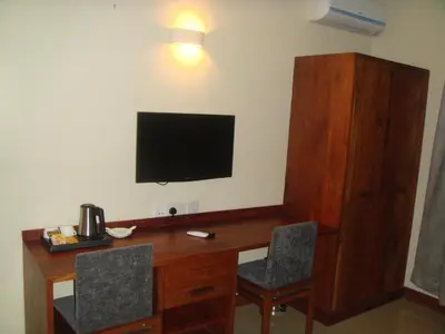 a desk with two chairs and a television on a wall at Venus Premier Hotel in Arusha
